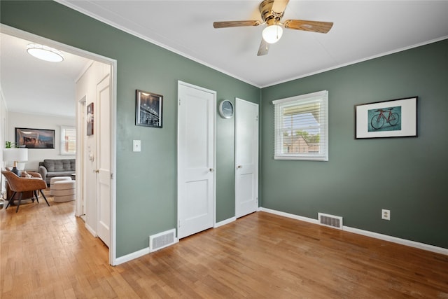 2012 61st St, Des Moines, IA 50322 - unfurnished bedroom with light wood finished floors, baseboards, ornamental molding, and ceiling fan