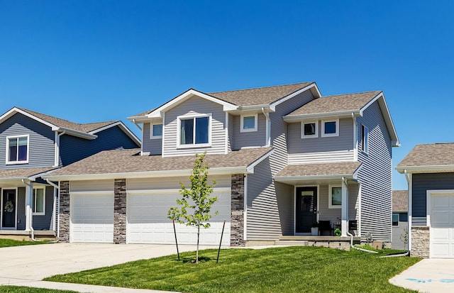 1001 Willow Valley Dr, Norwalk, IA 50211 - view of front of home featuring driveway, a shingled roof, a front lawn, stone siding, and a garage