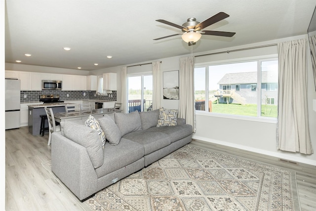 1001 Willow Valley Dr, Norwalk, IA 50211 - living area featuring light wood finished floors, a ceiling fan, baseboards, and recessed lighting