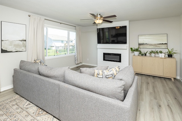1001 Willow Valley Dr, Norwalk, IA 50211 - living area with wood finished floors, a fireplace, a ceiling fan, and baseboards
