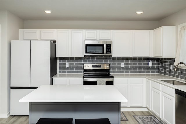 1001 Willow Valley Dr, Norwalk, IA 50211 - kitchen with stainless steel appliances, a sink, light wood-style floors, light countertops, and recessed lighting
