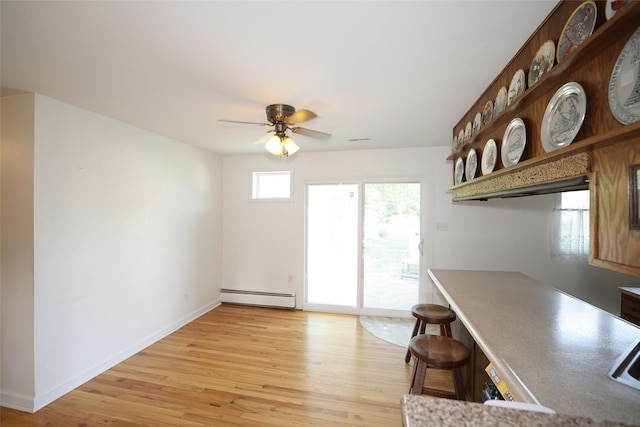 541 S Cedar St, Boone, IA 50036 - unfurnished dining area with baseboard heating, light wood finished floors, a ceiling fan, and baseboards