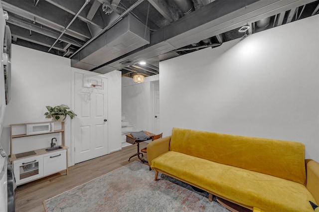 living area featuring light wood-style flooring and stairway