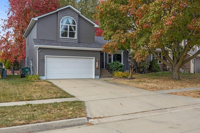 view of front of house with an attached garage, concrete driveway, a front lawn, and roof with shingles