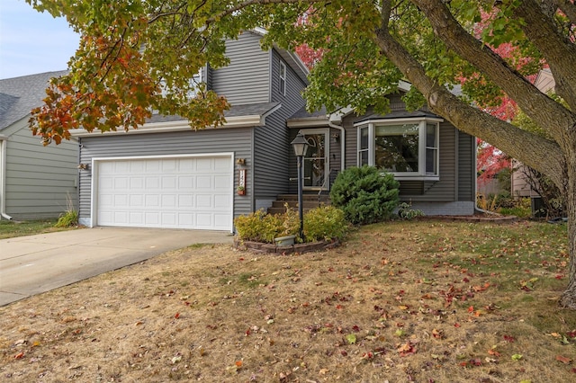 obstructed view of property with concrete driveway, a front yard, and a shingled roof