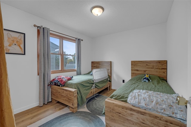 bedroom with baseboards and wood finished floors