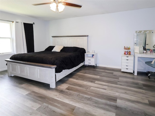bedroom featuring wood finished floors, a desk, and ceiling fan
