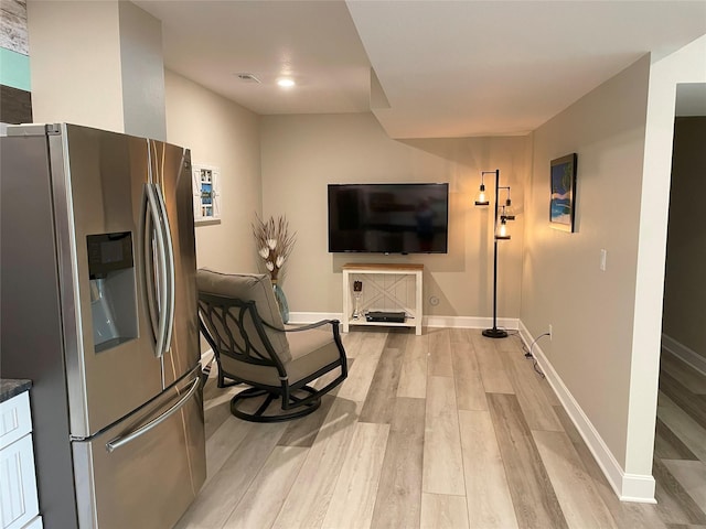 living area featuring light wood finished floors and baseboards