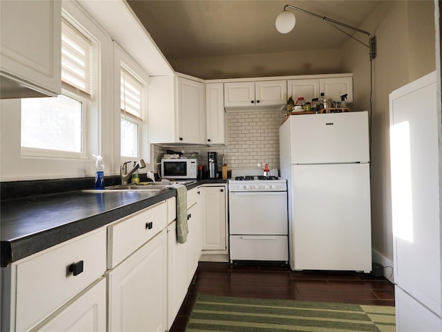 1321 Clark St, Des Moines, IA 50314 - kitchen featuring white appliances, dark countertops, white cabinetry, and tasteful backsplash