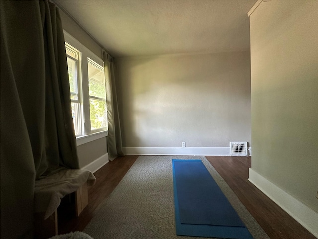 1321 Clark St, Des Moines, IA 50314 - unfurnished room with baseboards and dark wood-type flooring