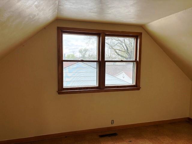 1604 Elder Dr, Marshalltown, IA 50158 - bonus room featuring lofted ceiling, baseboards, and carpet flooring