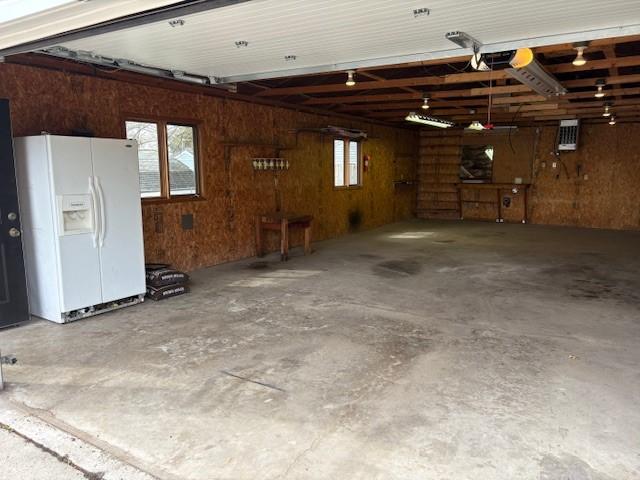 1604 Elder Dr, Marshalltown, IA 50158 - garage with white fridge with ice dispenser and wooden walls