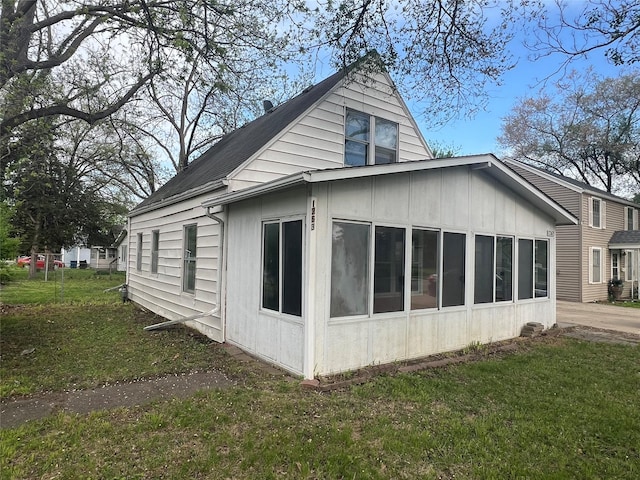 1263 E 25th St, Des Moines, IA 50317 - view of property exterior with a yard, board and batten siding, and a sunroom