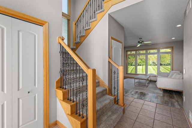 stairway featuring ceiling fan, tile patterned floors, baseboards, and recessed lighting