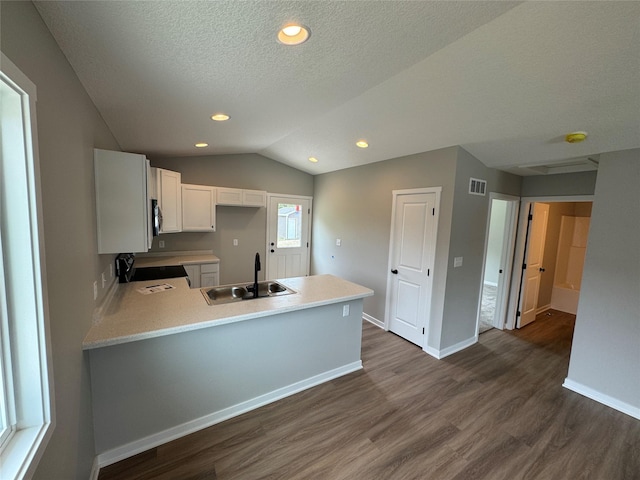 1533 Walker St, Des Moines, IA 50316 - kitchen with dark wood-type flooring, stove, a peninsula, light countertops, and white cabinetry