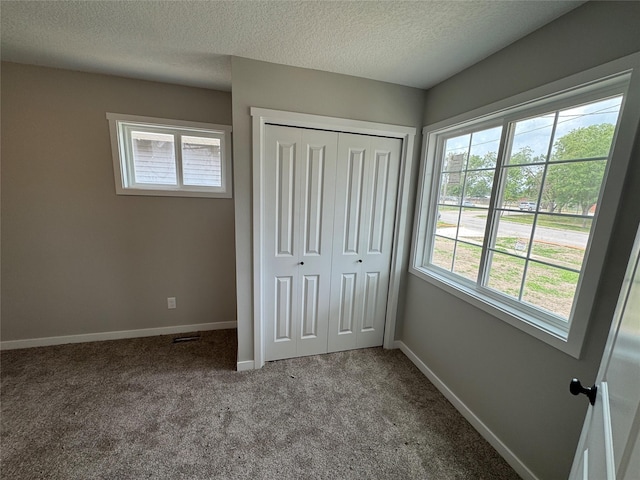 1533 Walker St, Des Moines, IA 50316 - unfurnished bedroom with carpet floors, a closet, multiple windows, and a textured ceiling