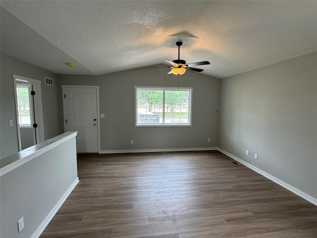 1533 Walker St, Des Moines, IA 50316 - unfurnished room with ceiling fan, dark wood-style floors, vaulted ceiling, and a textured ceiling