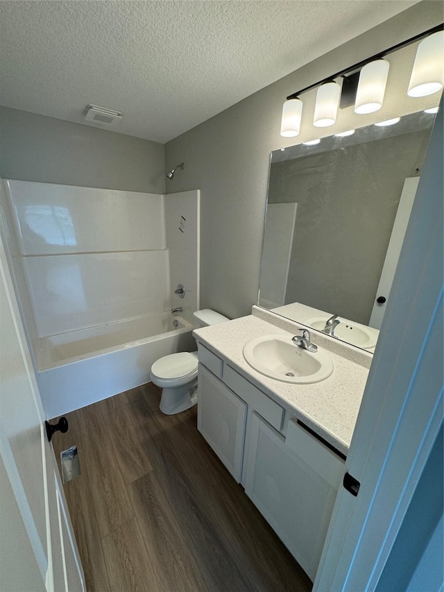 1533 Walker St, Des Moines, IA 50316 - bathroom featuring vanity, a textured ceiling, bathing tub / shower combination, and wood finished floors