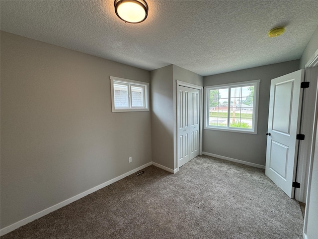1533 Walker St, Des Moines, IA 50316 - unfurnished bedroom featuring carpet floors, a textured ceiling, and a closet