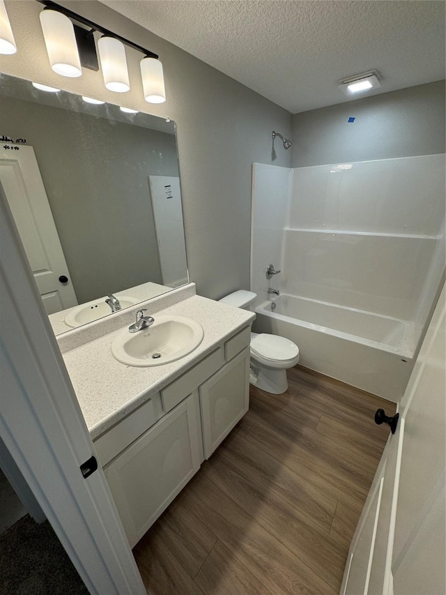 1533 Walker St, Des Moines, IA 50316 - full bathroom featuring vanity, tub / shower combination, a textured ceiling, and wood finished floors