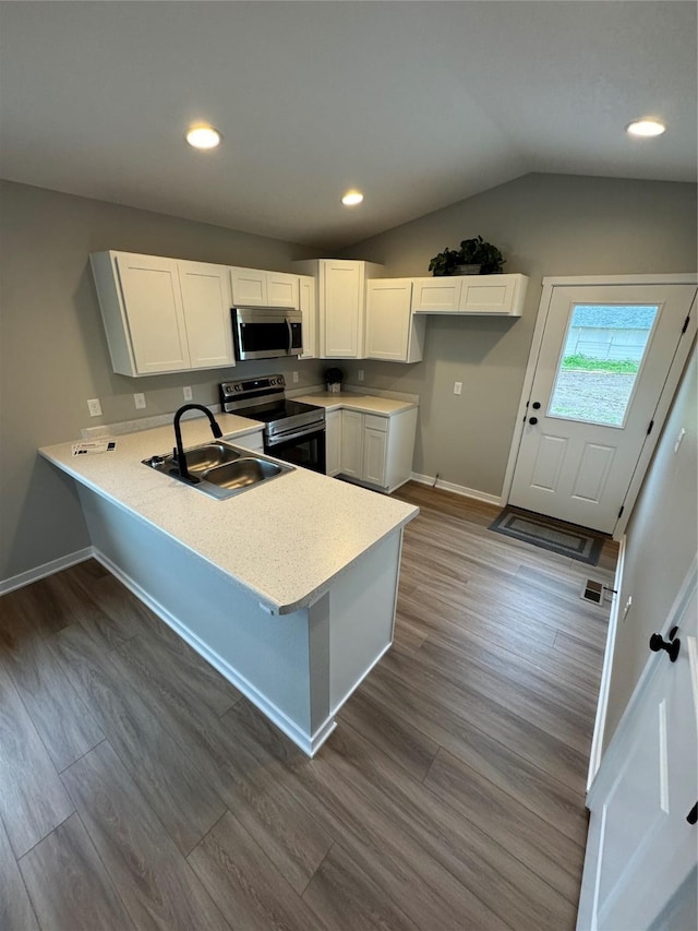 1533 Walker St, Des Moines, IA 50316 - kitchen with stainless steel appliances, a peninsula, dark wood-type flooring, light countertops, and white cabinets