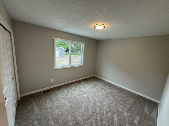 1533 Walker St, Des Moines, IA 50316 - unfurnished bedroom with carpet floors, a closet, and a textured ceiling