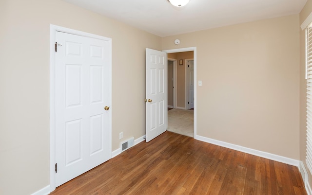 unfurnished bedroom with baseboards and wood finished floors