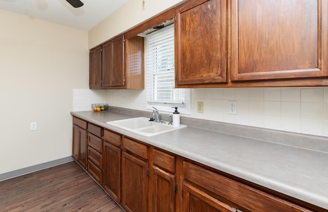kitchen with a sink, tasteful backsplash, dark wood-type flooring, ceiling fan, and baseboards