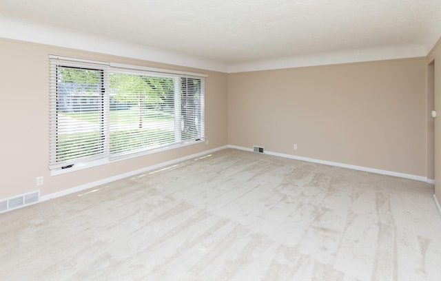 unfurnished room with light colored carpet and baseboards