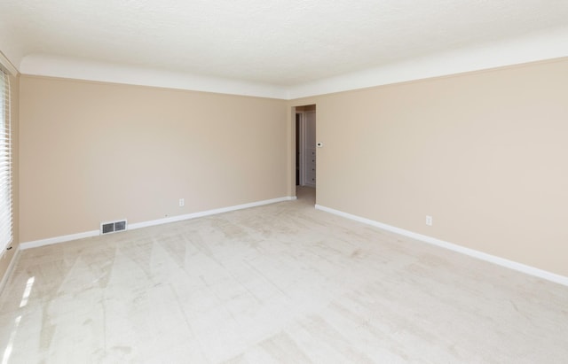 spare room with light colored carpet and baseboards