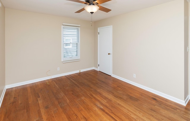 spare room featuring a ceiling fan, wood finished floors, and baseboards