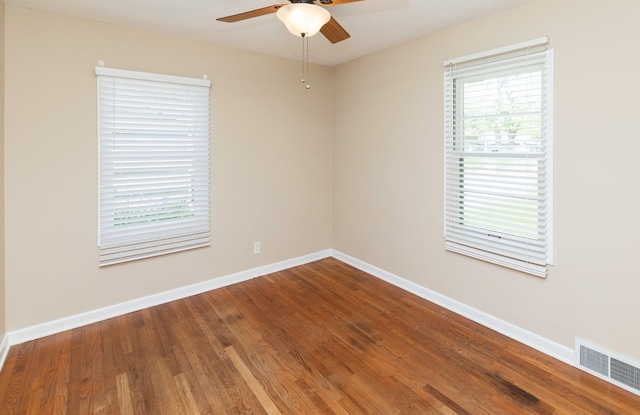 spare room featuring a ceiling fan, wood finished floors, and baseboards