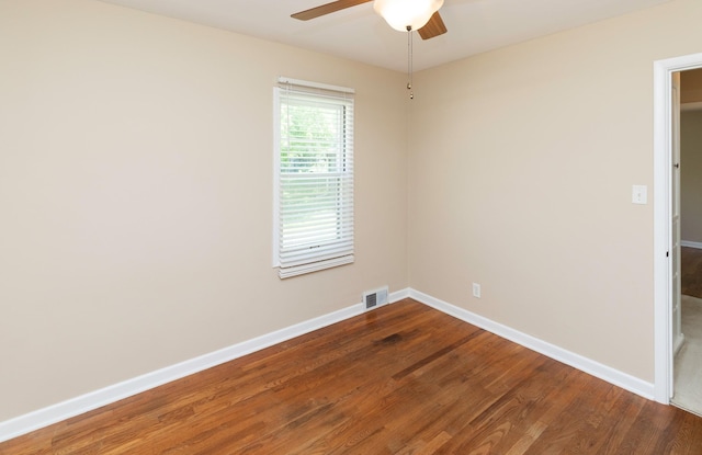 spare room featuring a ceiling fan, wood finished floors, and baseboards