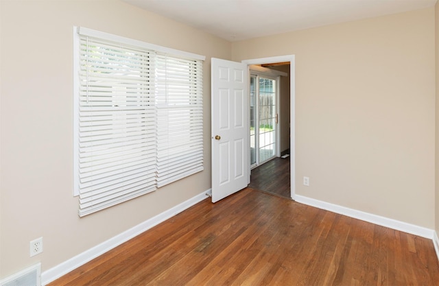 unfurnished room with wood finished floors and baseboards