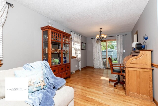 6404 Meredith Dr, Urbandale, IA 50322 - office with a chandelier, light wood-style floors, a textured ceiling, and baseboards