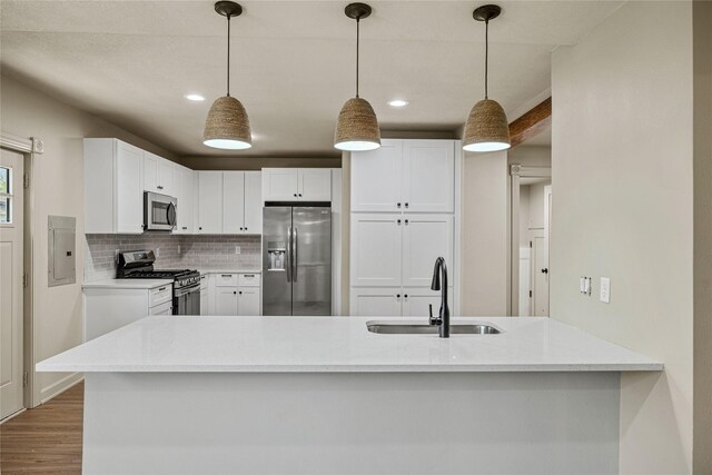 504 9th St, West Des Moines, IA 50265 - kitchen with stainless steel appliances, a sink, wood finished floors, decorative backsplash, and recessed lighting
