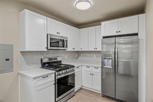 504 9th St, West Des Moines, IA 50265 - kitchen with stainless steel appliances, electric panel, light countertops, white cabinetry, and tasteful backsplash