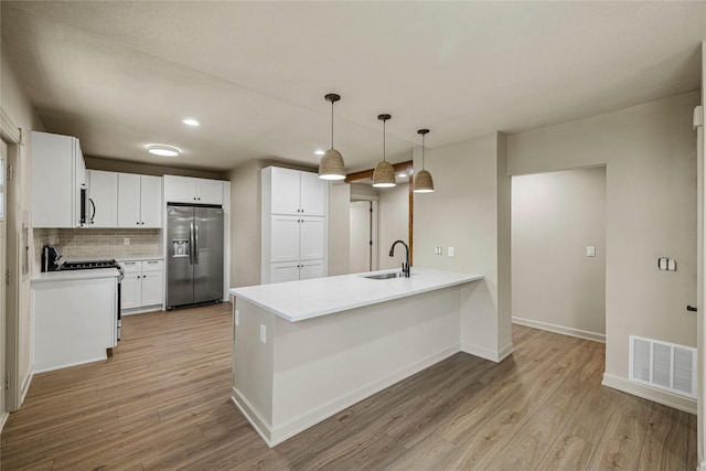 504 9th St, West Des Moines, IA 50265 - kitchen with stainless steel appliances, a peninsula, a sink, light wood-type flooring, and recessed lighting