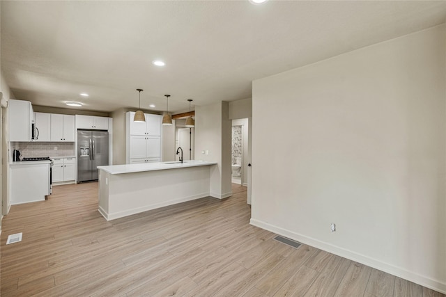 504 9th St, West Des Moines, IA 50265 - kitchen featuring stainless steel fridge, recessed lighting, baseboards, light wood-style floors, and decorative backsplash