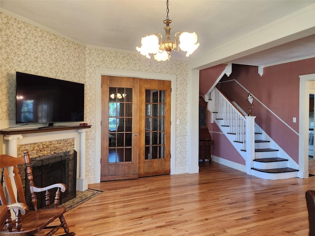 903 Greene St, Adel, IA 50003 - unfurnished living room featuring a chandelier, stairway, wood finished floors, ornamental molding, and wallpapered walls