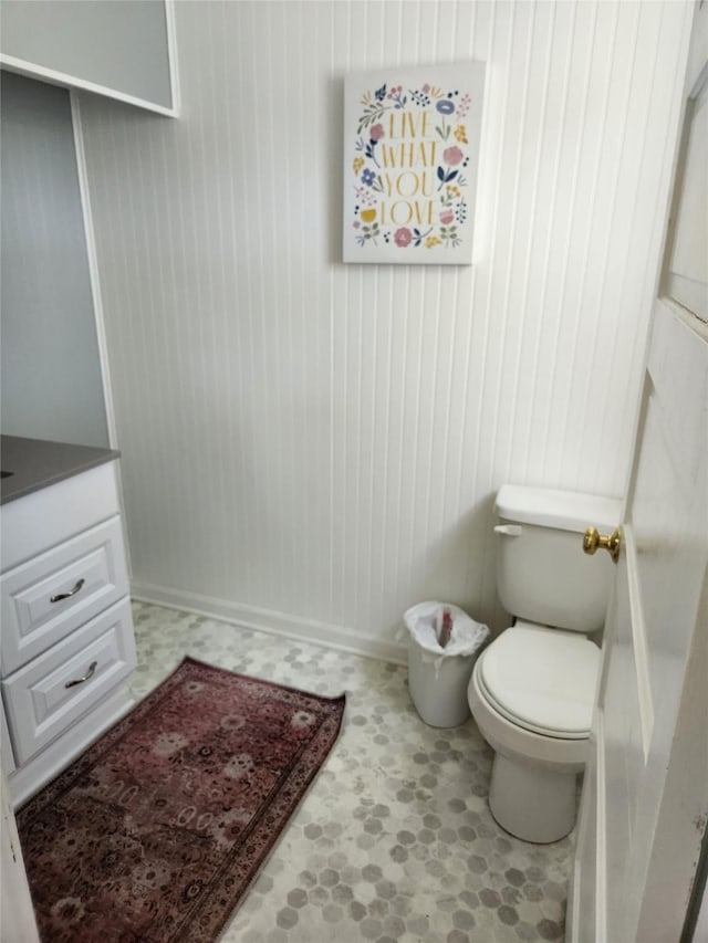 903 Greene St, Adel, IA 50003 - bathroom featuring tile patterned floors, toilet, and wooden walls