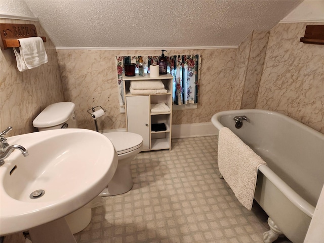 903 Greene St, Adel, IA 50003 - full bathroom featuring a textured ceiling, tile patterned floors, toilet, a soaking tub, and a sink