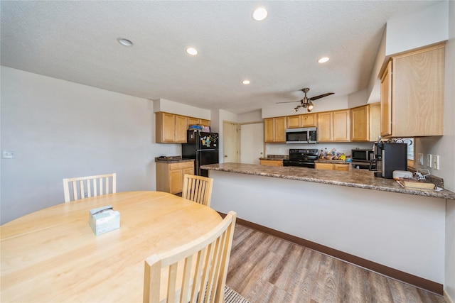 612 W Pleasant St, Pleasantville, IA 50225 - kitchen with black appliances, a peninsula, light wood-style flooring, ceiling fan, and recessed lighting