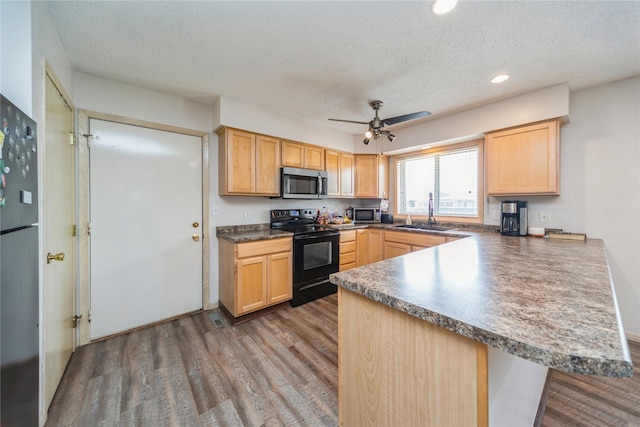 612 W Pleasant St, Pleasantville, IA 50225 - kitchen featuring black appliances, a textured ceiling, a peninsula, light brown cabinetry, and wood finished floors
