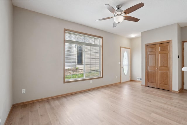unfurnished room featuring light wood-type flooring, plenty of natural light, ceiling fan, and baseboards
