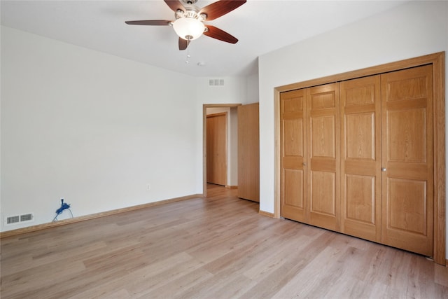 unfurnished bedroom featuring light wood-style floors, a closet, a ceiling fan, and baseboards