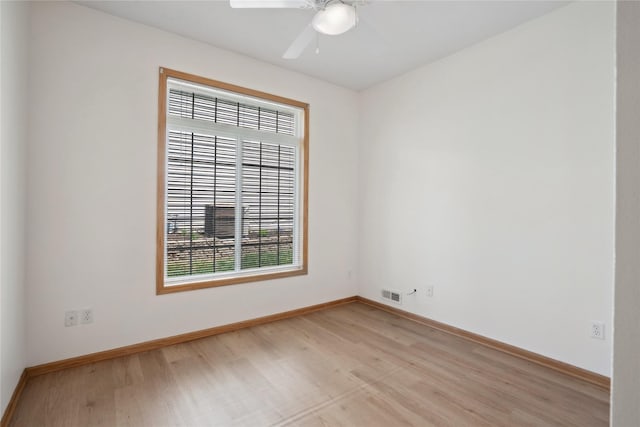 empty room featuring light wood-style floors, baseboards, and a ceiling fan