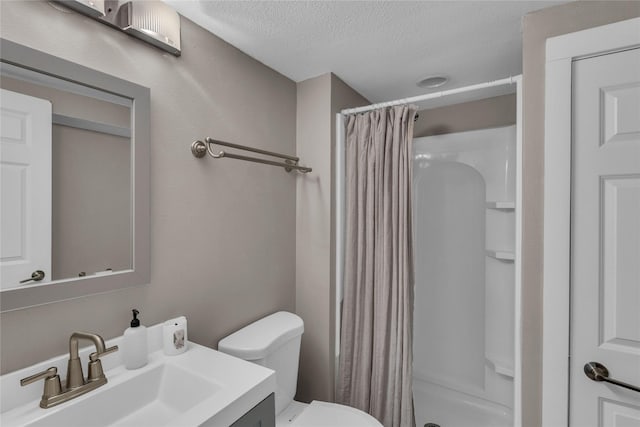 full bath with a textured ceiling, a stall shower, toilet, and vanity
