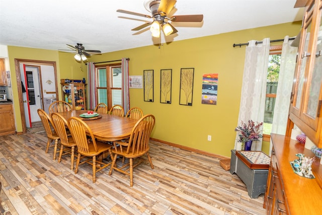 dining area with a ceiling fan, light wood-style flooring, and baseboards