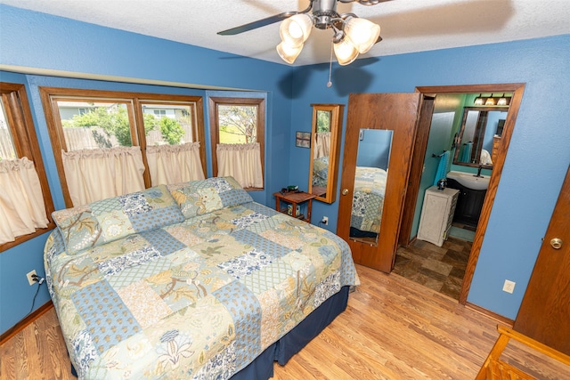 bedroom with wood finished floors, access to outside, a ceiling fan, baseboards, and a textured ceiling